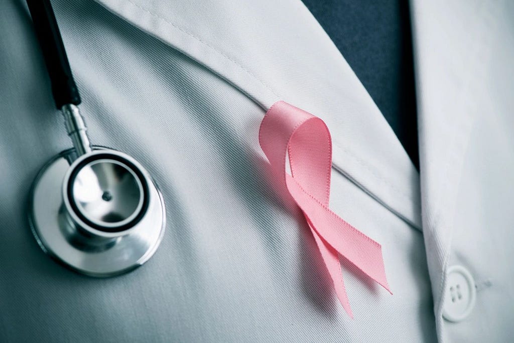 doctor’s lapel showing the end of the stethescope and a breast cancer pink ribbon