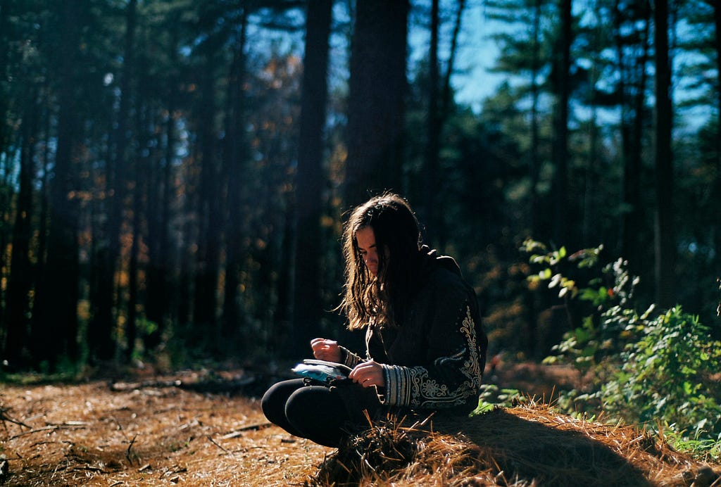 Girl writing in a serene forest