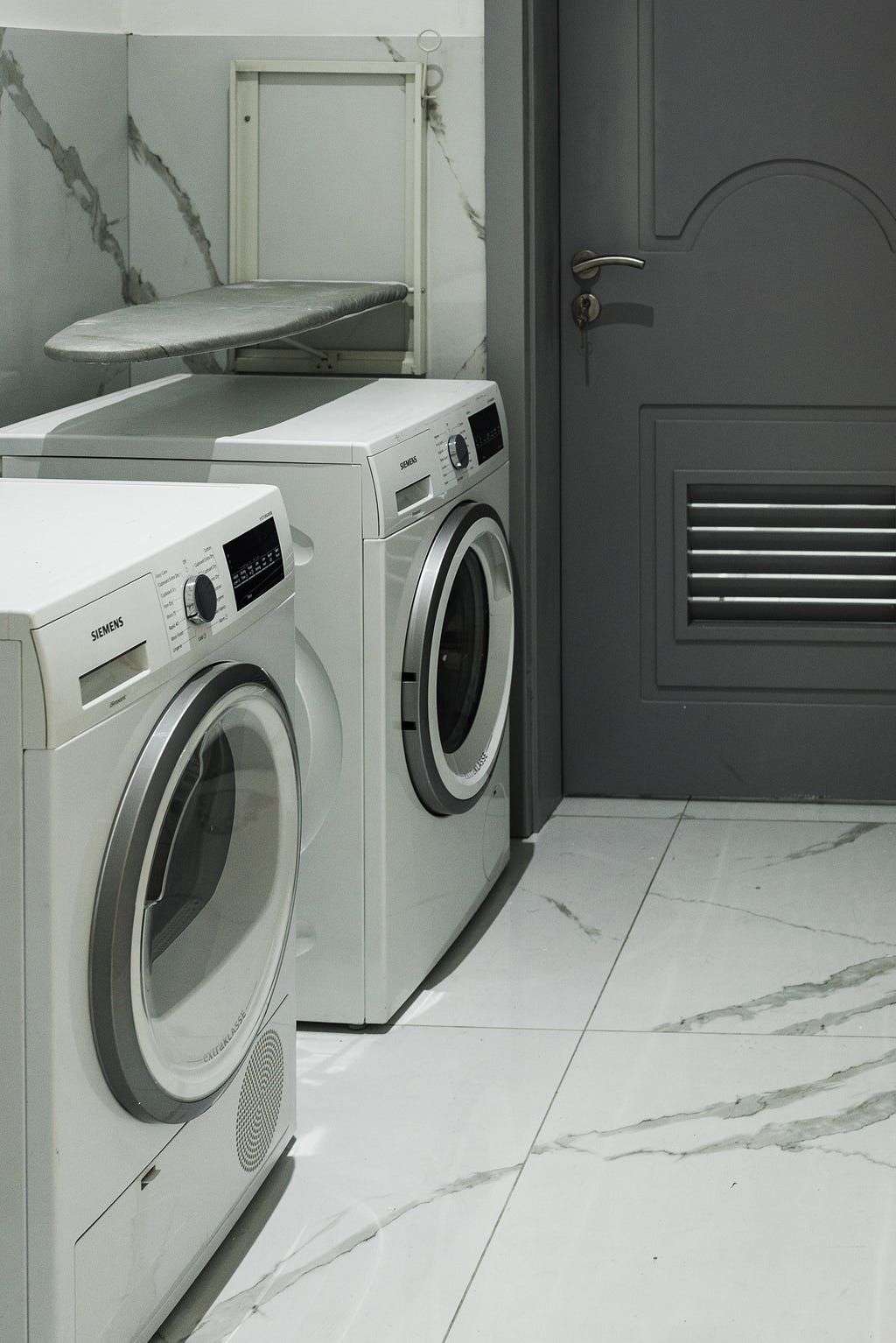 Picture of two clothes washers, side by side, in a laundry room.