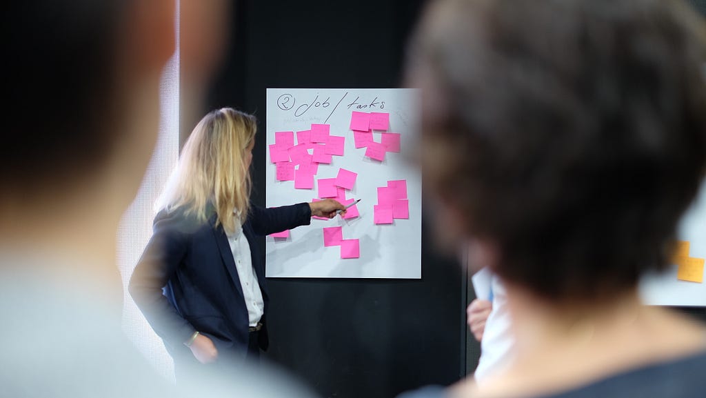 A presenter using clustered sticky notes.