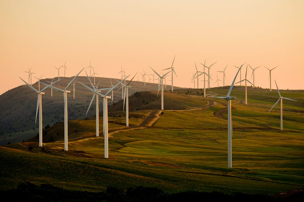 Top of a mountain dotted with white windmills.