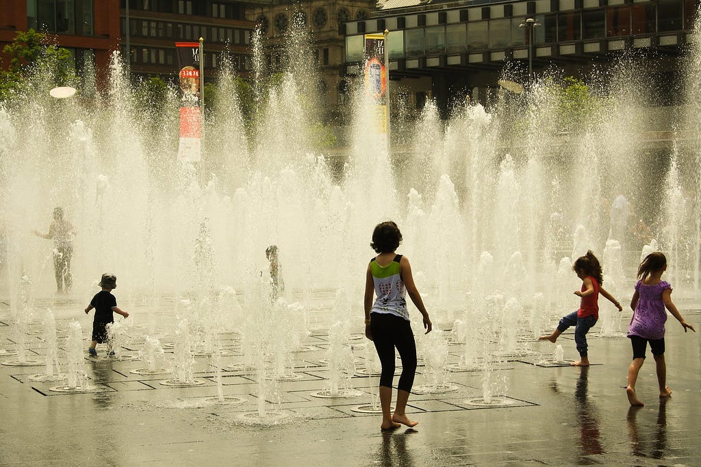 Hot summer: kids playing in fountain