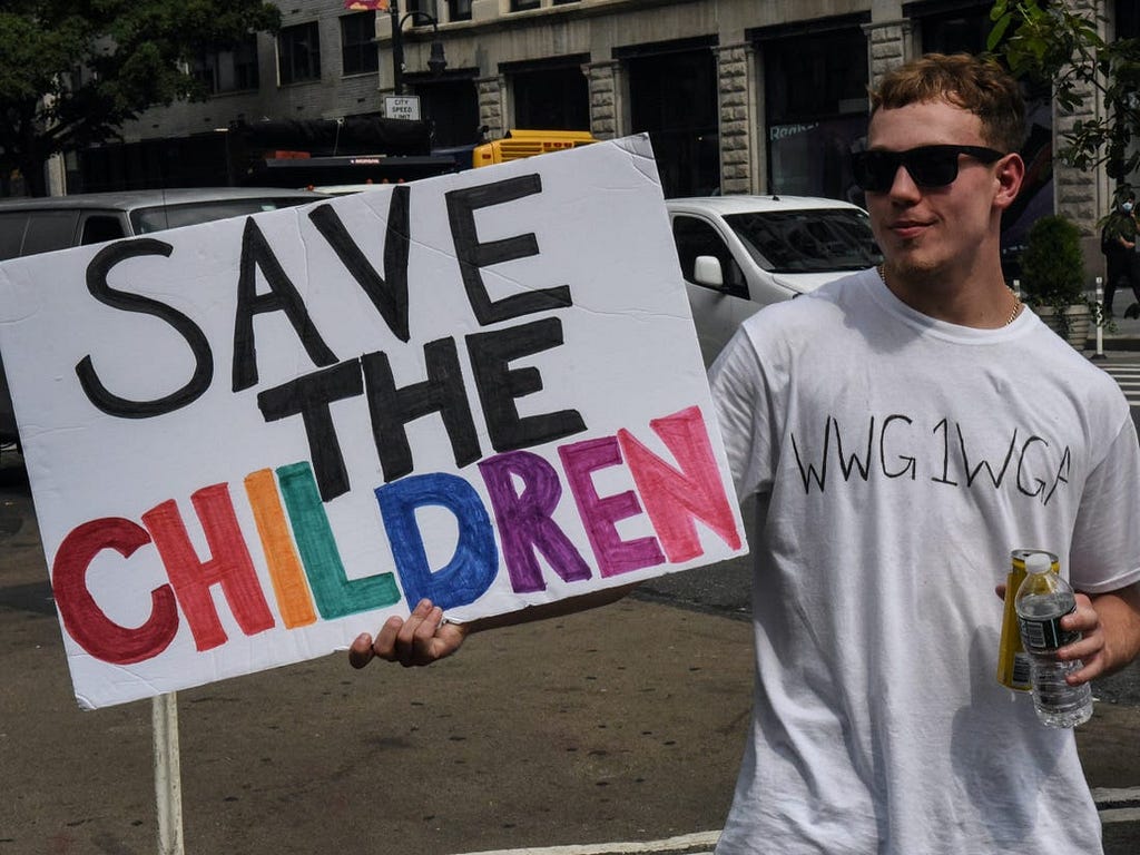 A person wearing a T-shirt that says “WWG1WGA,” a QAnon slogan, at a “Save the Children” march.