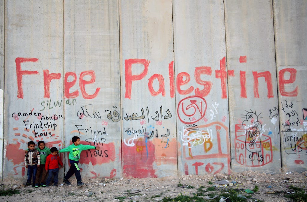 Unos niños palestinos en el 'lado oriental' del muro de separación israelí, cerca de la aldea de Abu Dis, el 3 de abril de 2014. (Foto: Said Qaq / APA Images)