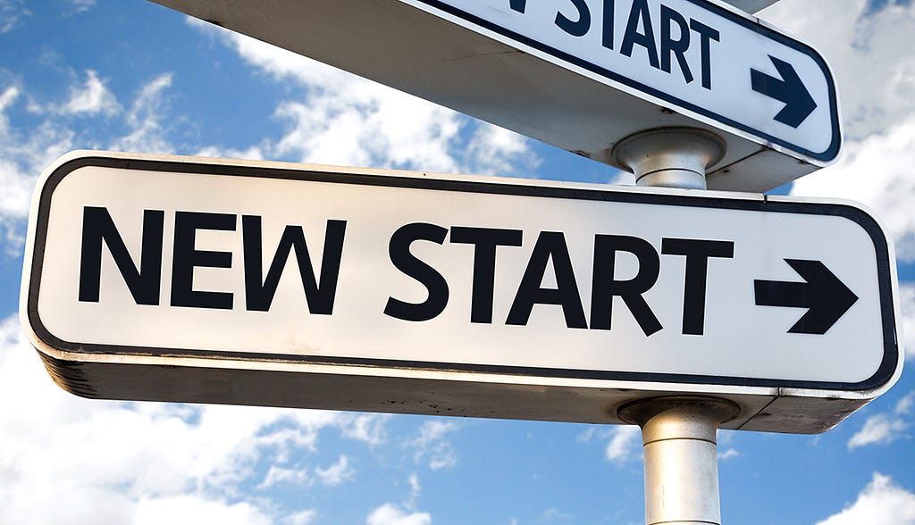 A sign with an arrow and “New Start” written on it