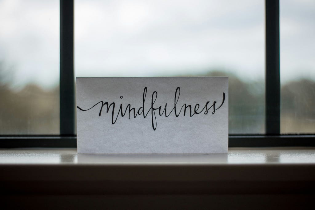 Piece of white paper with the word “Mindfulness” handwritten on it.