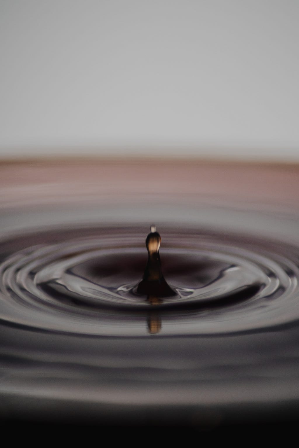 A drop of water rebounding from a pool after it hits.