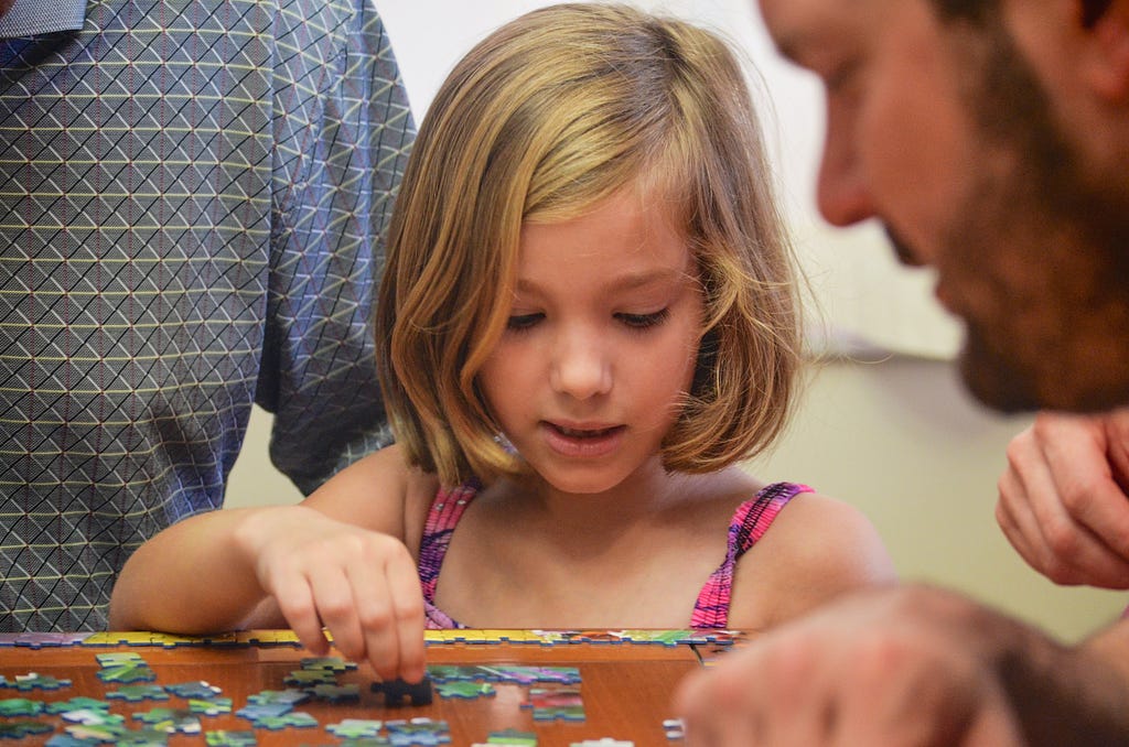 Young kid laying out a jigsaw puzzle