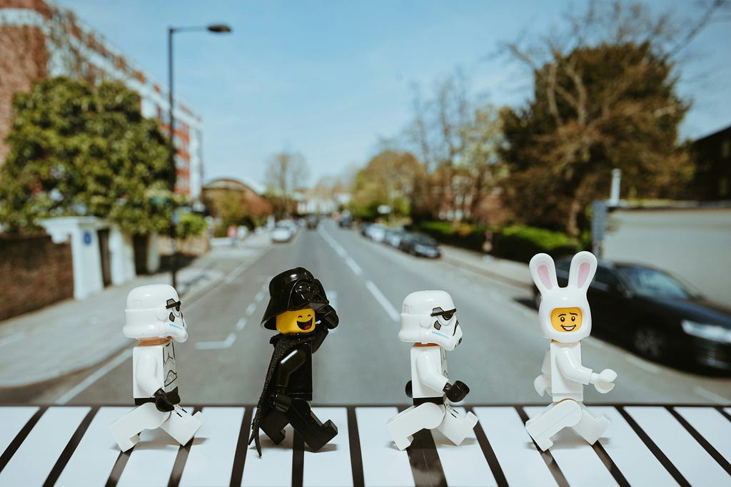 Image of a crosswalk with 4 Lego figures crossing: dressed as a bunny, a white storm trouper, a black storm trouper and another white storm trooper