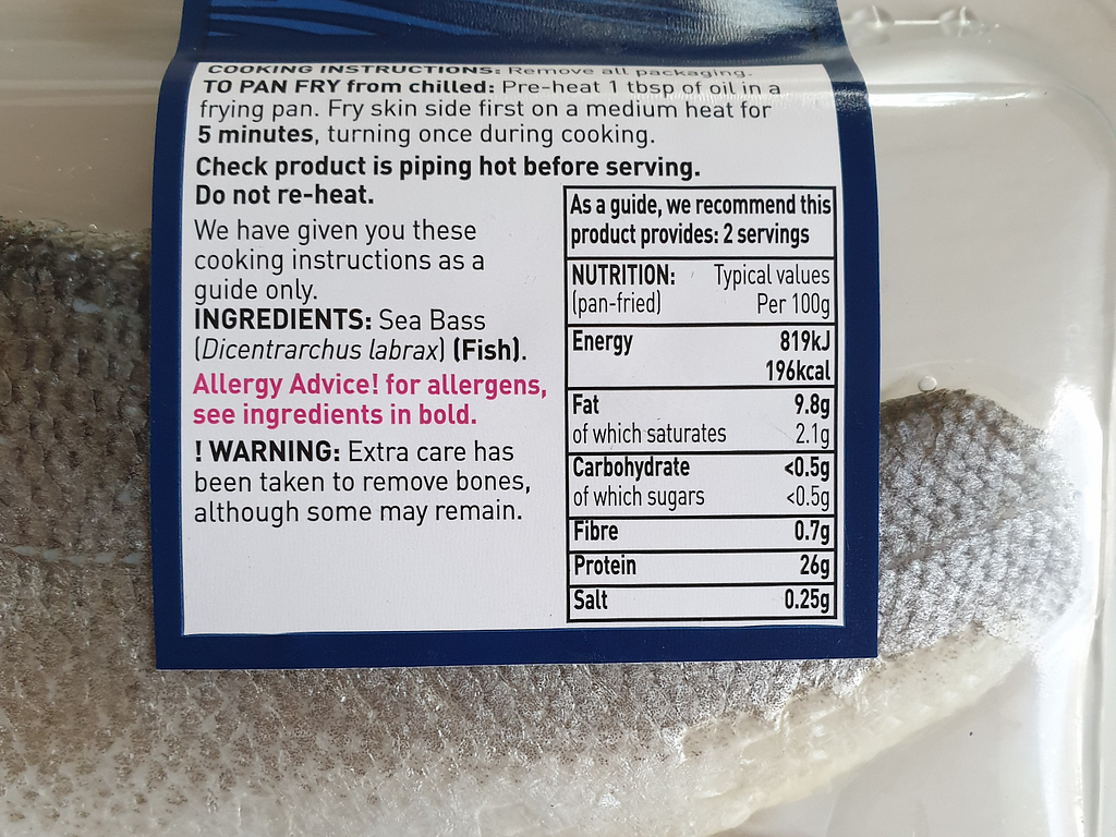 Sea bass in plastic packaging with white label describing nutritional content