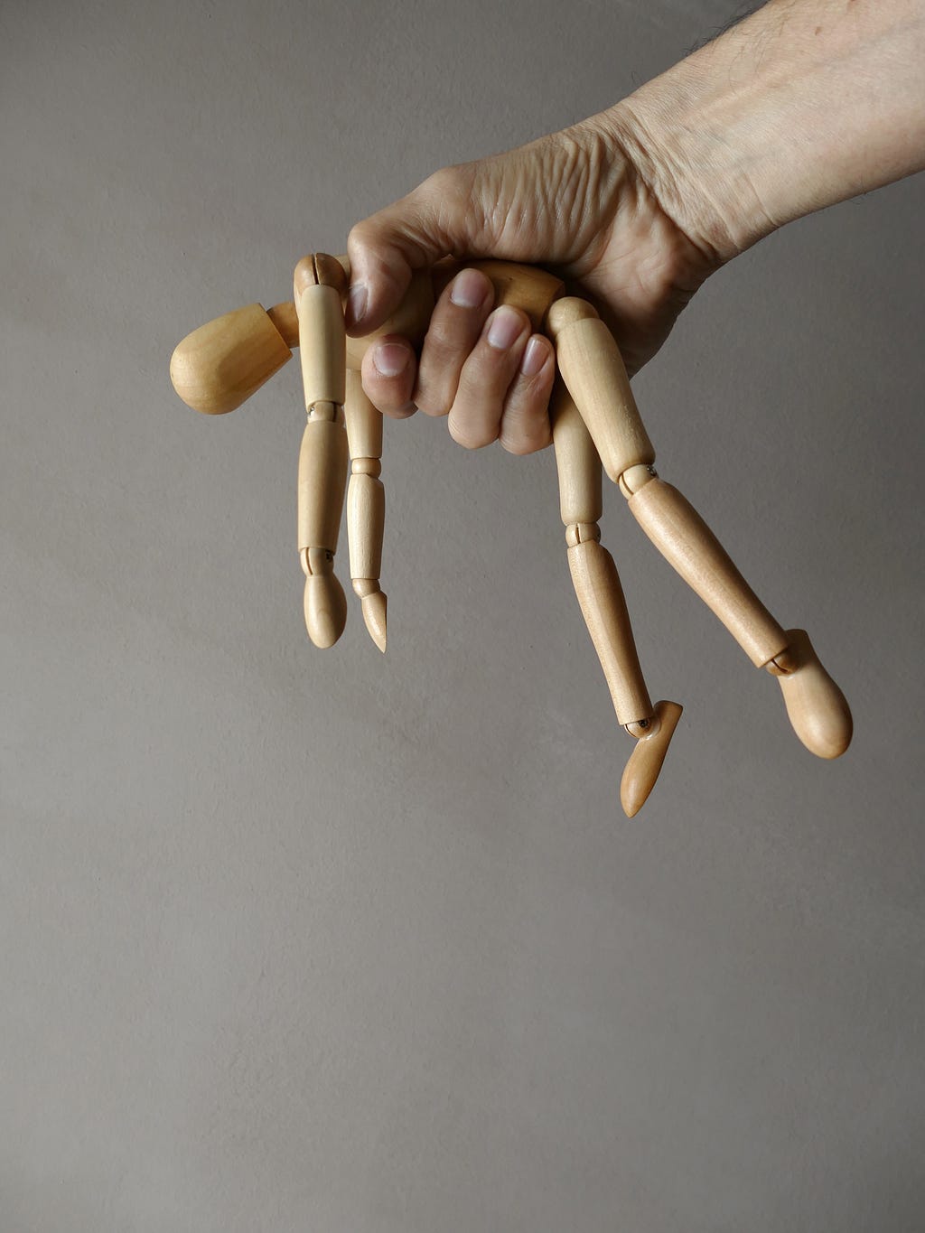 A man holding a wooden toy in his fist.