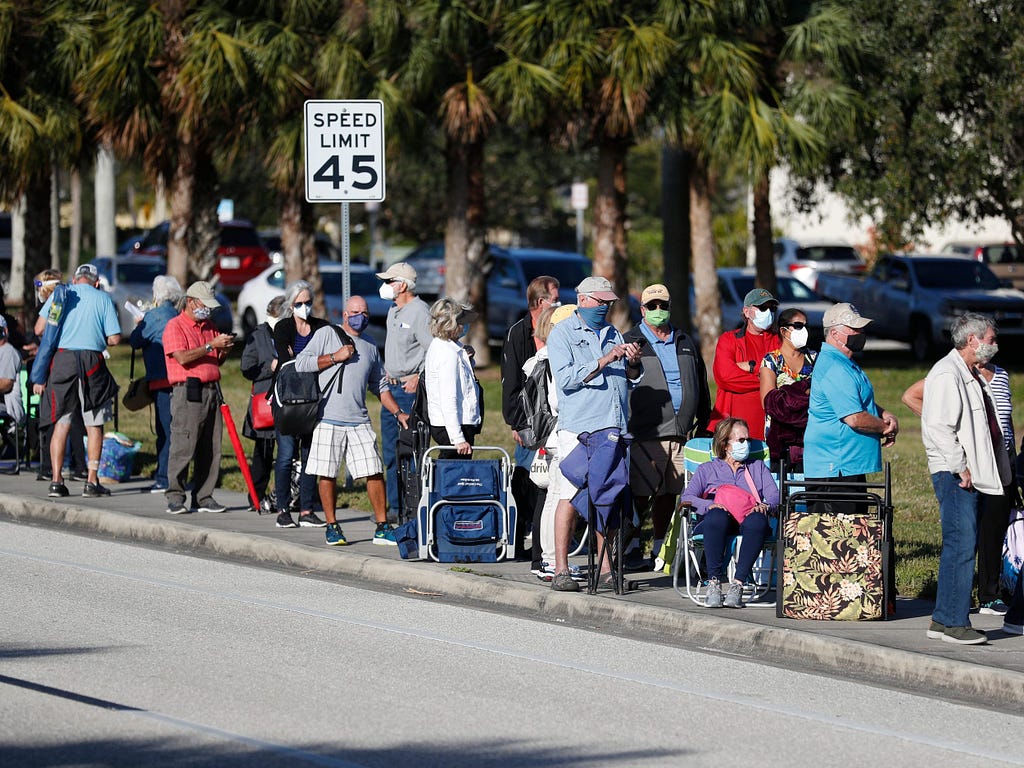 Seniors and first responders wait in line to receive a COVID-19 vaccine at the Lakes Regional Library in Fort Myers, Florida.