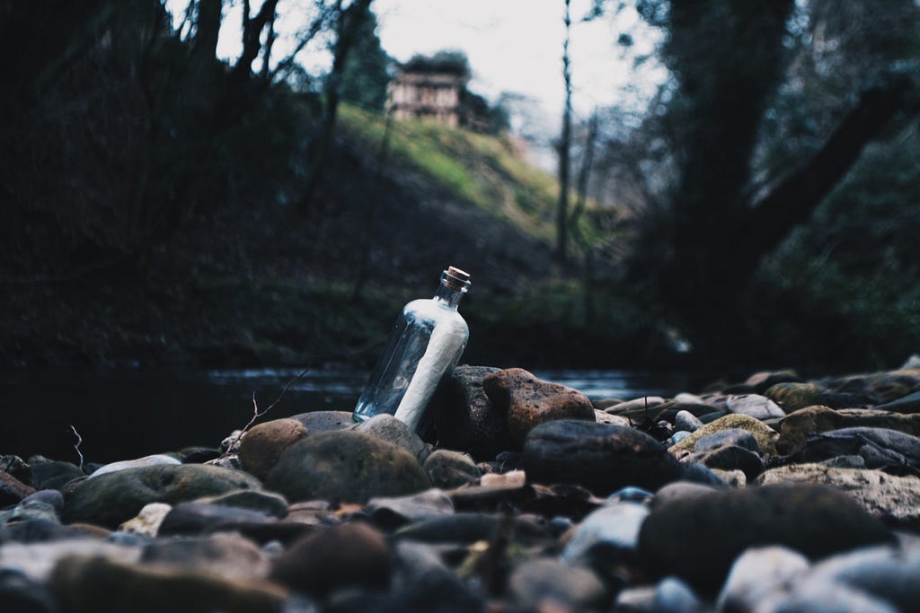 Botella con un mensaje dentro flotando en un río, simbolizando la comunicación y la conexión a través de mensajes en el agua.