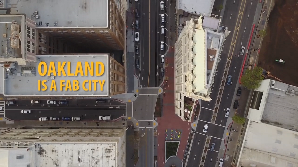 A bird’s eye view of Oakland with the words “Oakland is a Fab City” overlaid on one of the building’s rooftops.