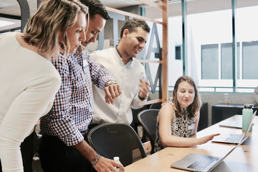 two ladies and two men standing in a conference room.