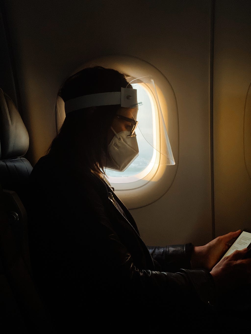 Passageira usando máscara e faceshield como forma de prevenção à COVID-19 em voo.