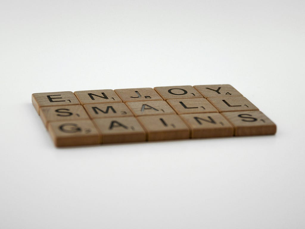 Enjoy small gains written in Scrabble tiles