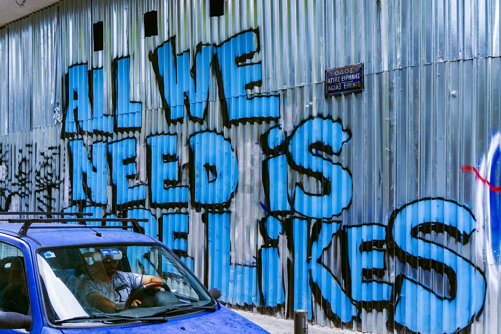 sign on a building saying, “all we need is more likes” for a brand to build their social media presence