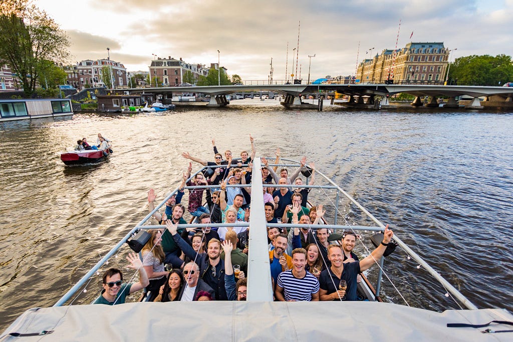 Imagem dos colaboradores da Superhero Cheescake em um barco nos canais de amsterdam
