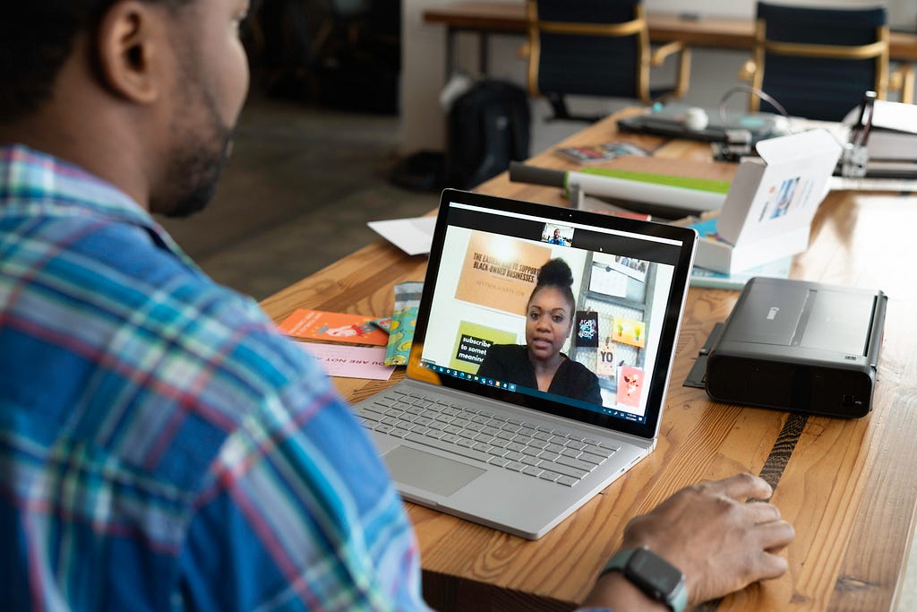 A guy communicating on the laptop with a lady, giving interview on the remote connection