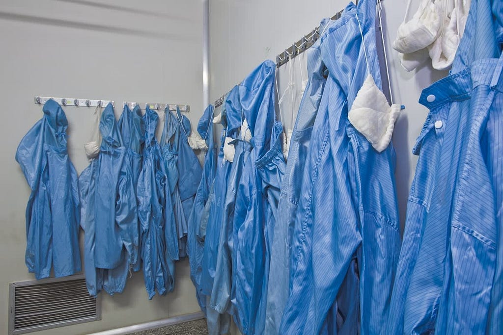 PPE equipment hanging on hooks in a room.