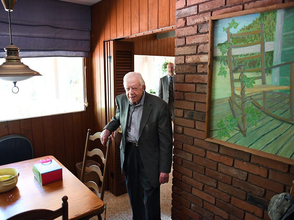 Jimmy Carter next to his painting.