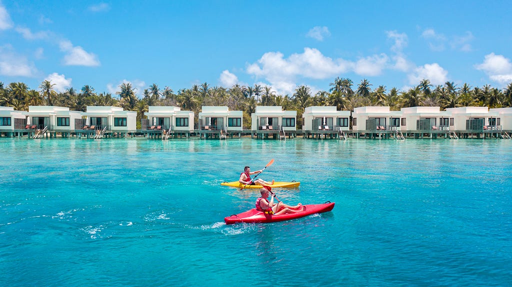 Photographs of two people on kayaks with holiday appartments in the background.