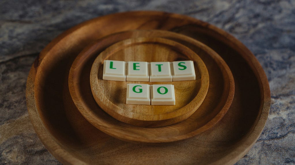 Series of wooden plates with the letters on top spelling out, let’s go — photo by Afif Ramdhasuma