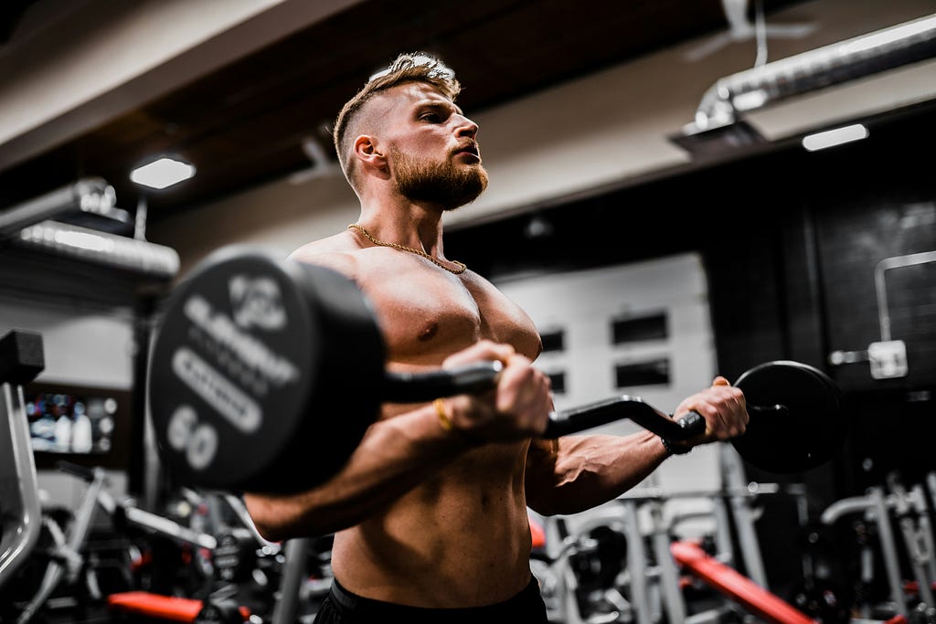 A gym athlete is doing upper body workout for bicep