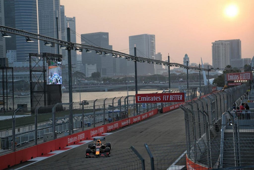 Formula 1 car on the Singapore GP track, with the sun setting in the background