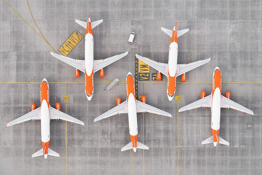 “AIRPORTS 100” by Tom Hegen shows grounded planes from above.