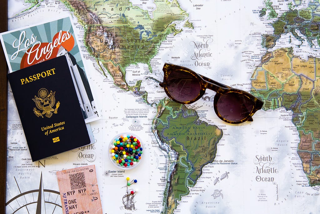 map with passport, brochures, and sunglasses