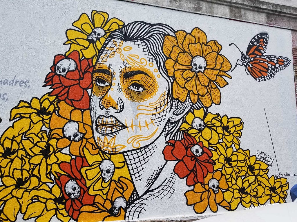 A mural in Austin, Texas of a woman with flowers and skulls created by Christin Apodaca.