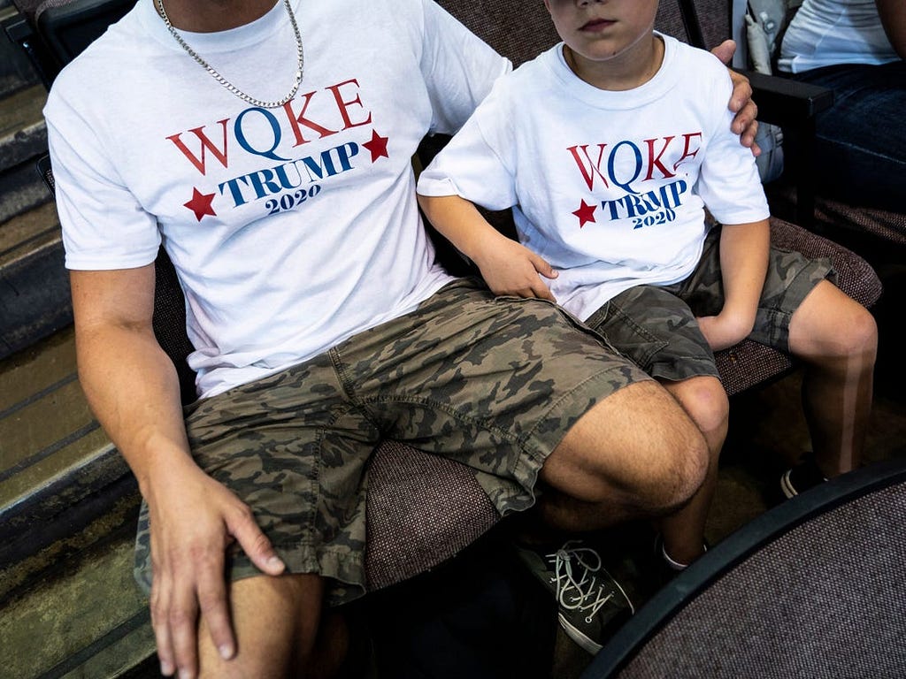 A father and son in QAnon shirts at a “Keep America Great” rally in Cincinnati on August 1, 2019.