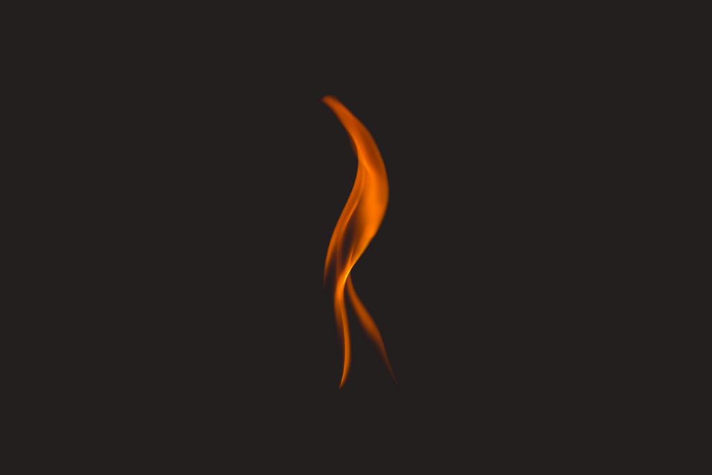 A single orange flame against a black background