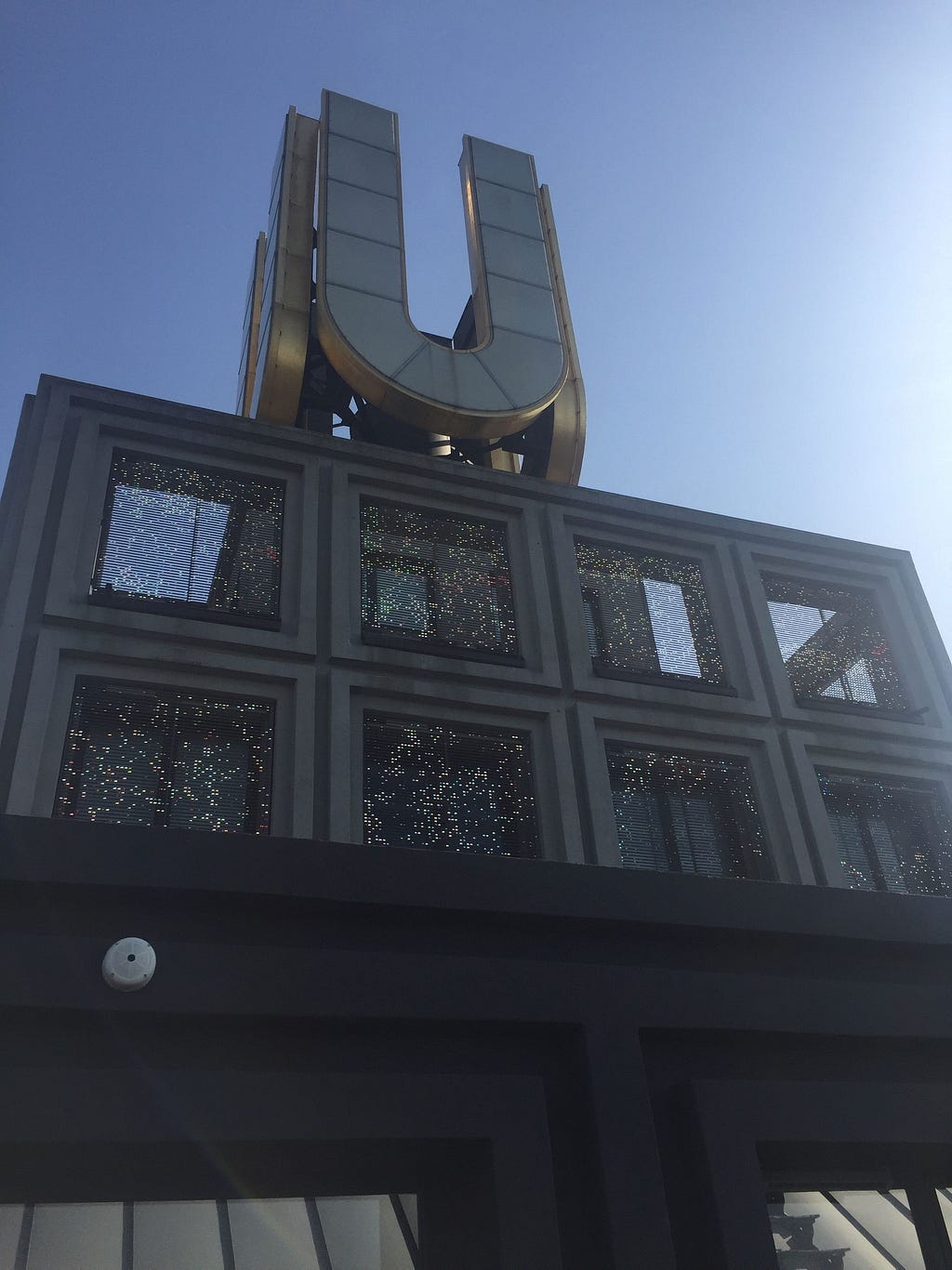 The top of a building with a large metal “U”