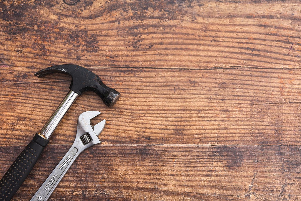 Tools on a table. Hammer and spanner.