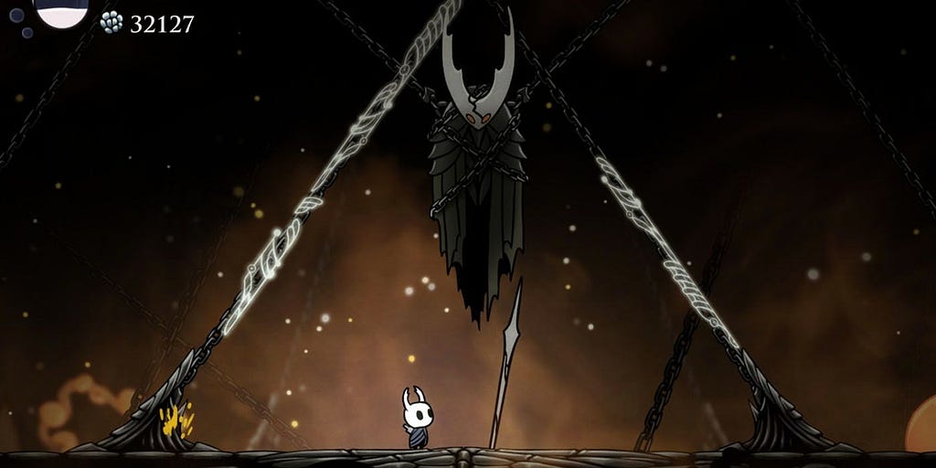 The Hollow Knight boss from Hollow Knight, suspended in chains over the player.