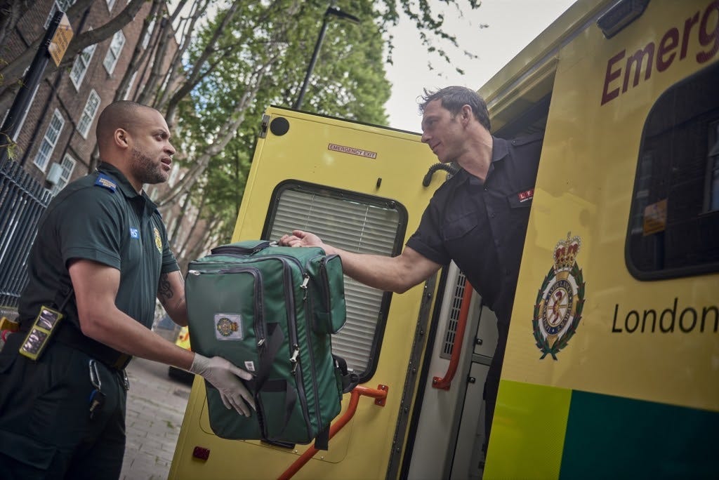 A paramedic (left) works with a firefighter (right) in London