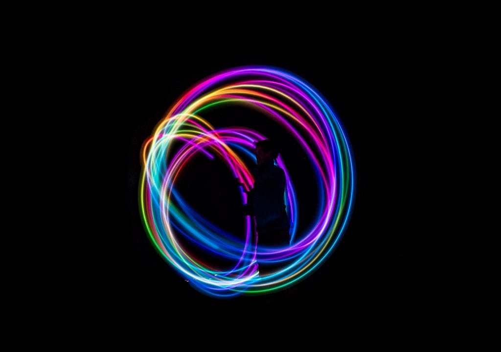 Time-lapse photography, colourful lights in a circle on a black background