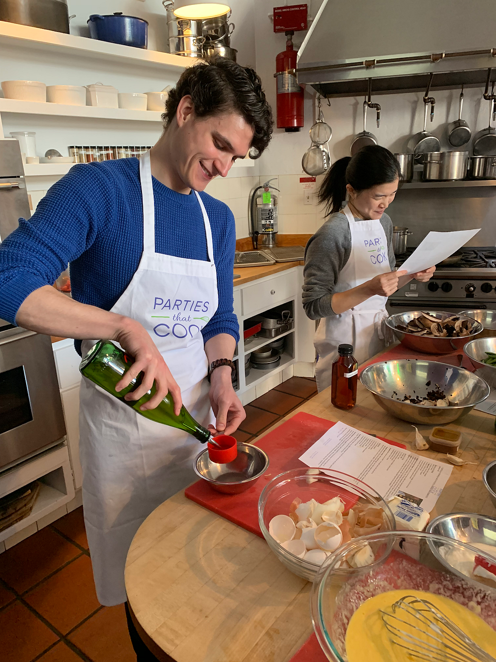 (From right to left) Mason and Michelle learning a new recipe during our company cooking class in May 2019.