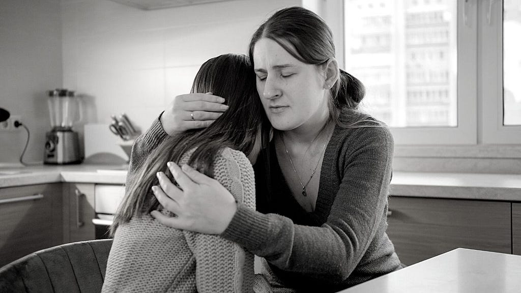 Mother hugging her teen daughter