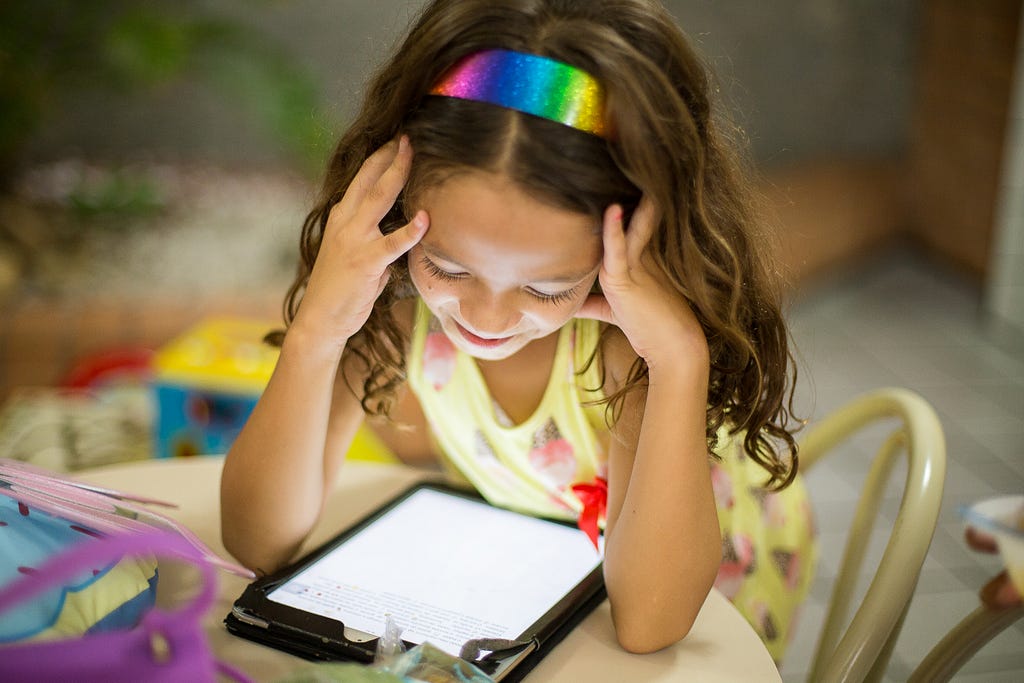 A kid reading a tablet