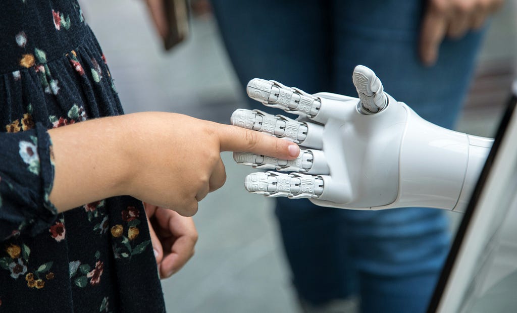 A human finger touching a robotic hand, representing the essential partnership between human judgment and AI capability in modern cybersecurity operations.