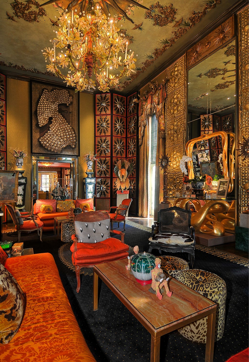 Tony Duquette’s Dawnridge interior. Features gold panels with red furnishings, mirrors, patterened fabrics and art.