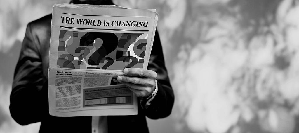 Un uomo legge un quotidiano su cui si legge “The world is changing”