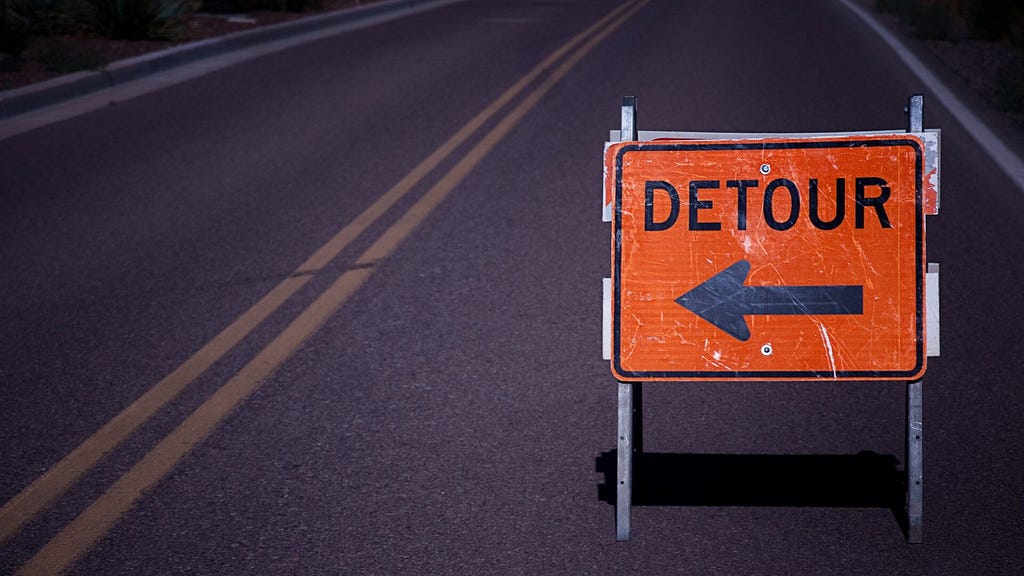 Detour sign on a stretch of empty road.
