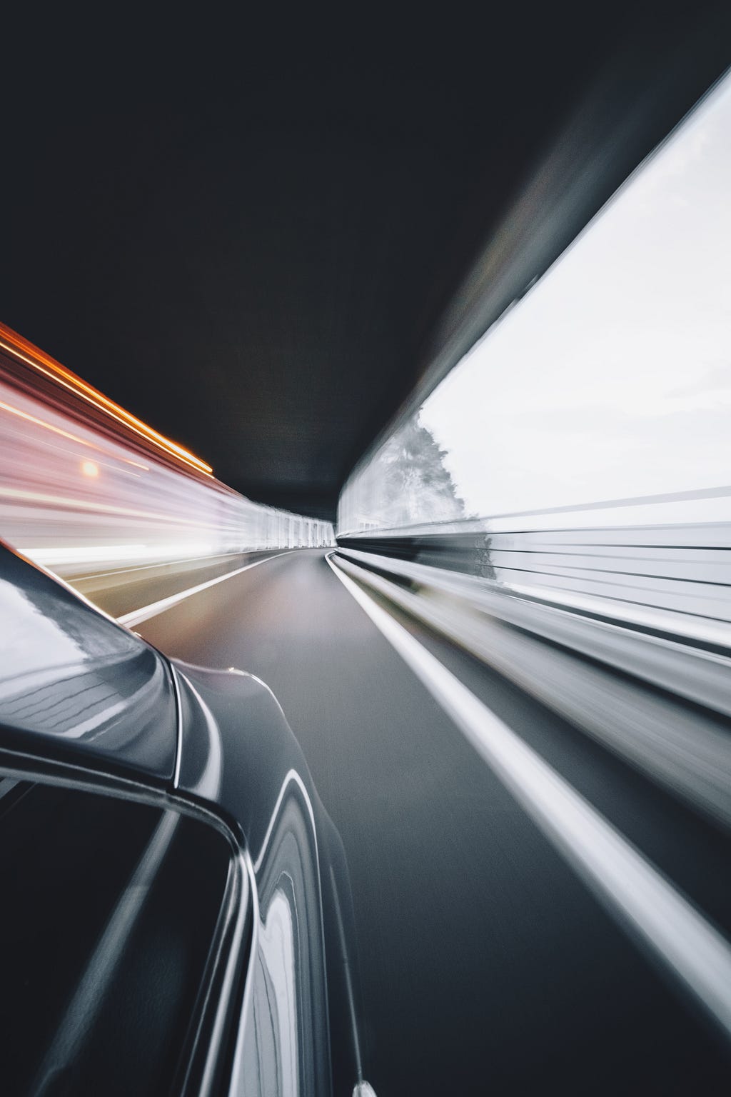 Speedy image of a car blazing through a tunnel.