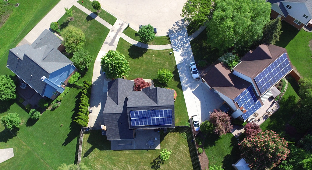 bird’s eye view of houses with solar panels on their roofs