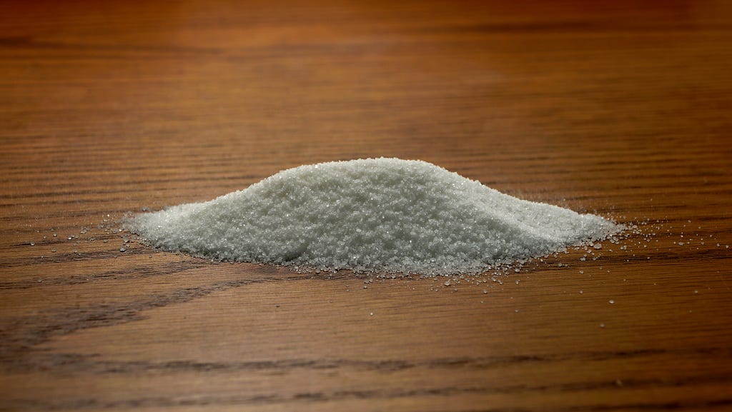 Pile of sugar on a wooden desk